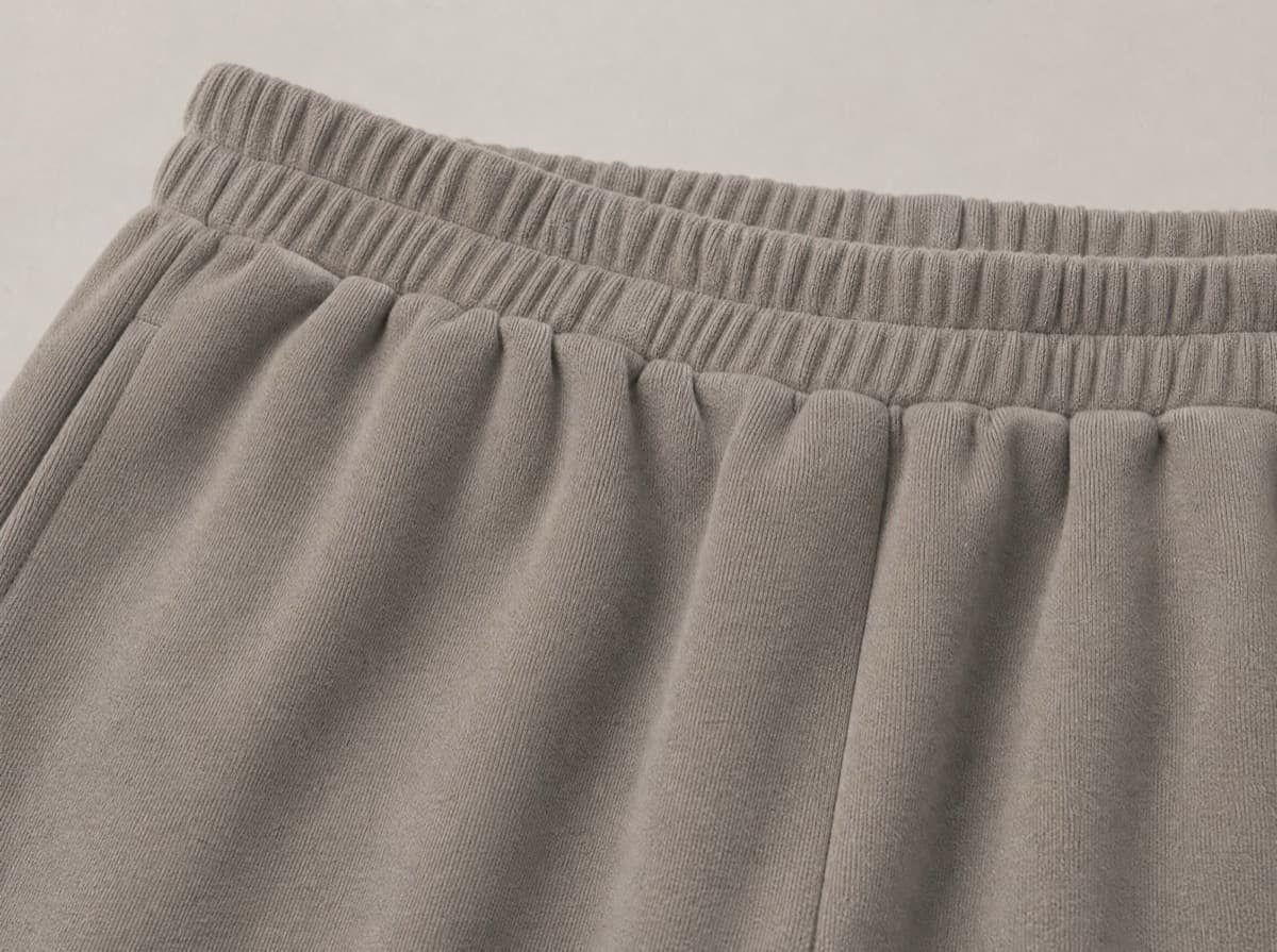 Close-up of a wide fully elasticated knitted waistband with no button, no hook and no rigid facing anywhere along it.