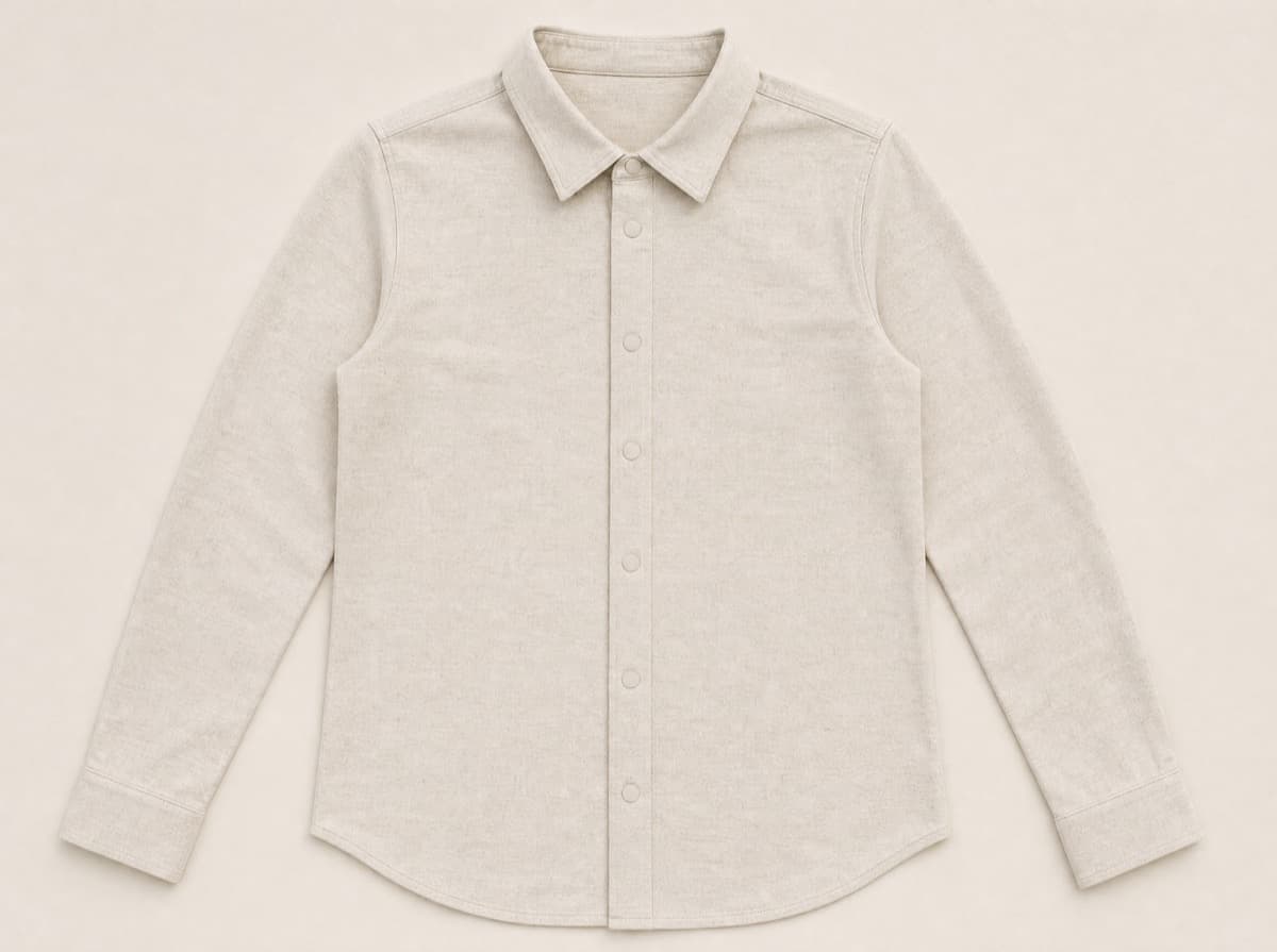 An oatmeal cotton shirt laid flat with a clean front placket held closed by discreet fabric-covered magnetic discs instead of buttons.
