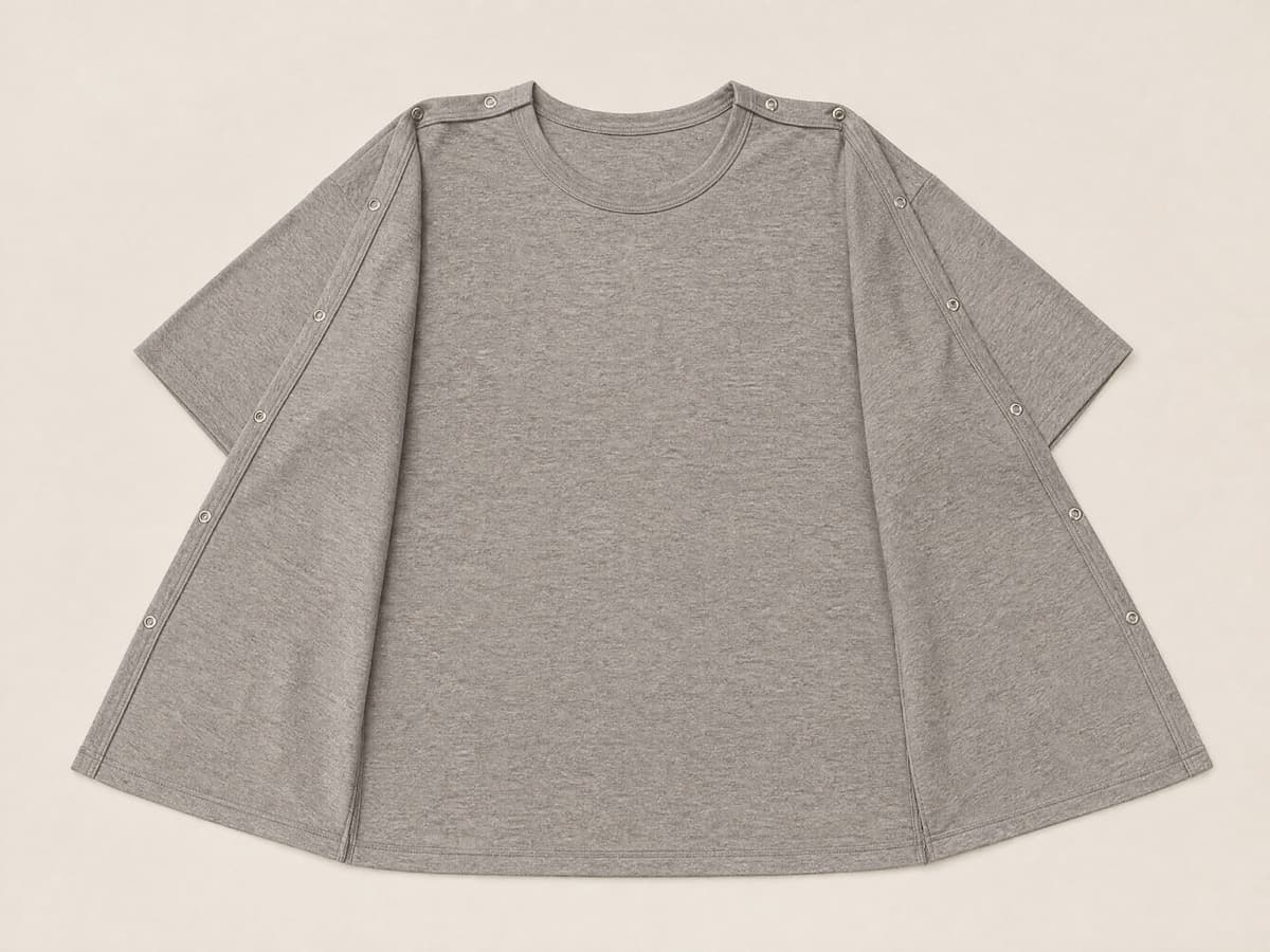 The same t-shirt with both shoulder seams fully opened so the front panel folds down flat away from the back panel.