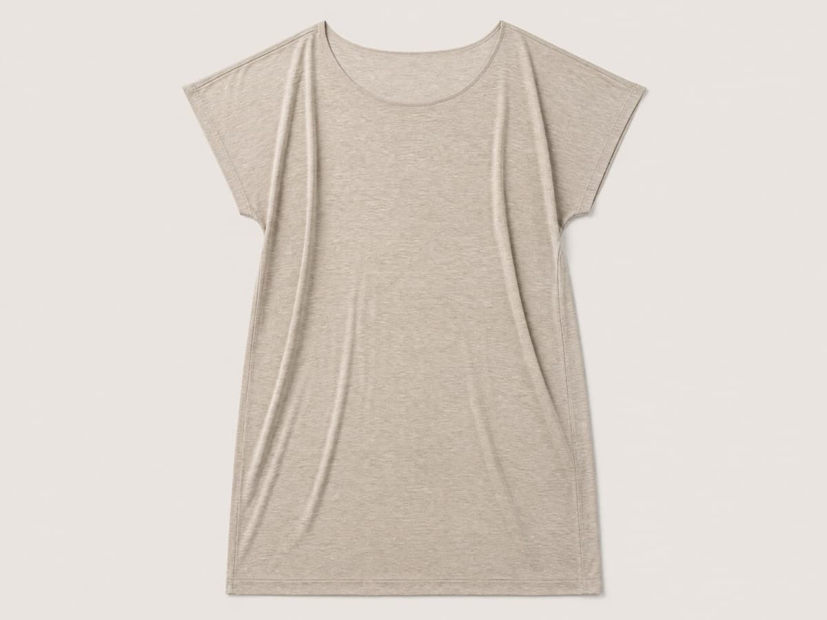 A mid-length soft sand jersey dress laid flat with a very wide relaxed neckline and no fasteners anywhere on the garment.